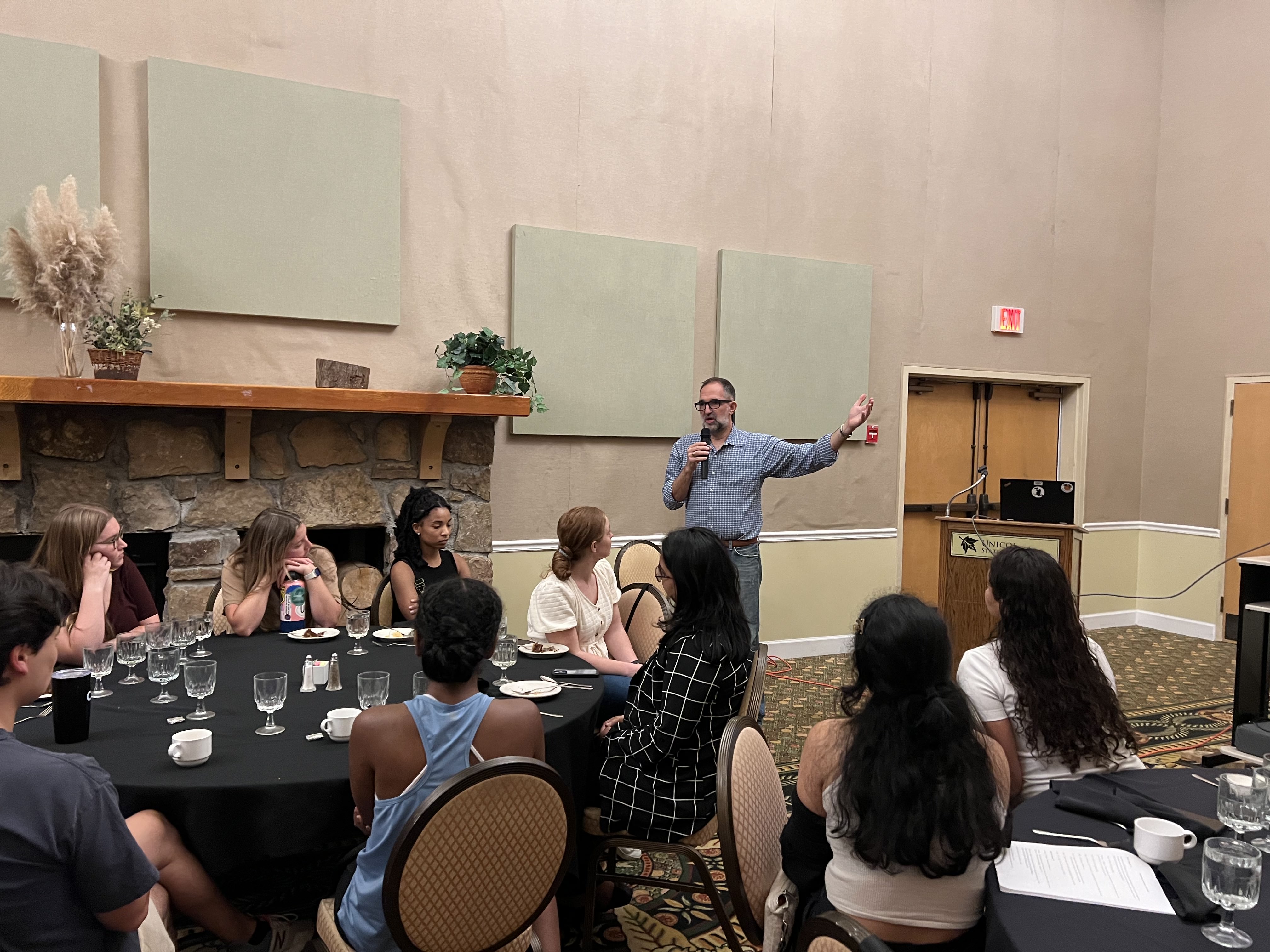 Ben Jordan speaking into microphone to MSEEM Students in a conference room.