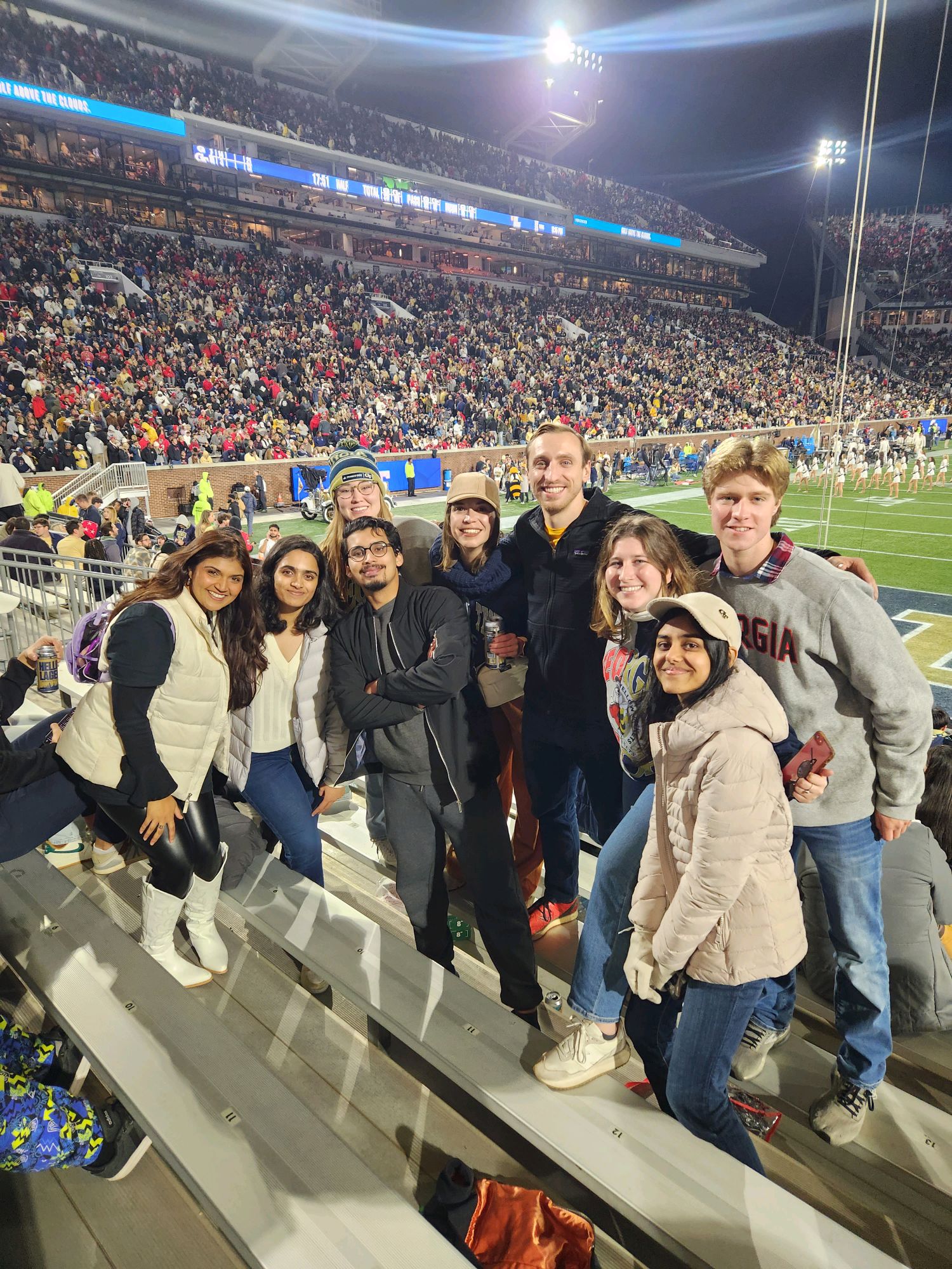 MSEEM Students gathered together at a Georgia Tech Football Game Smiling in front of the field