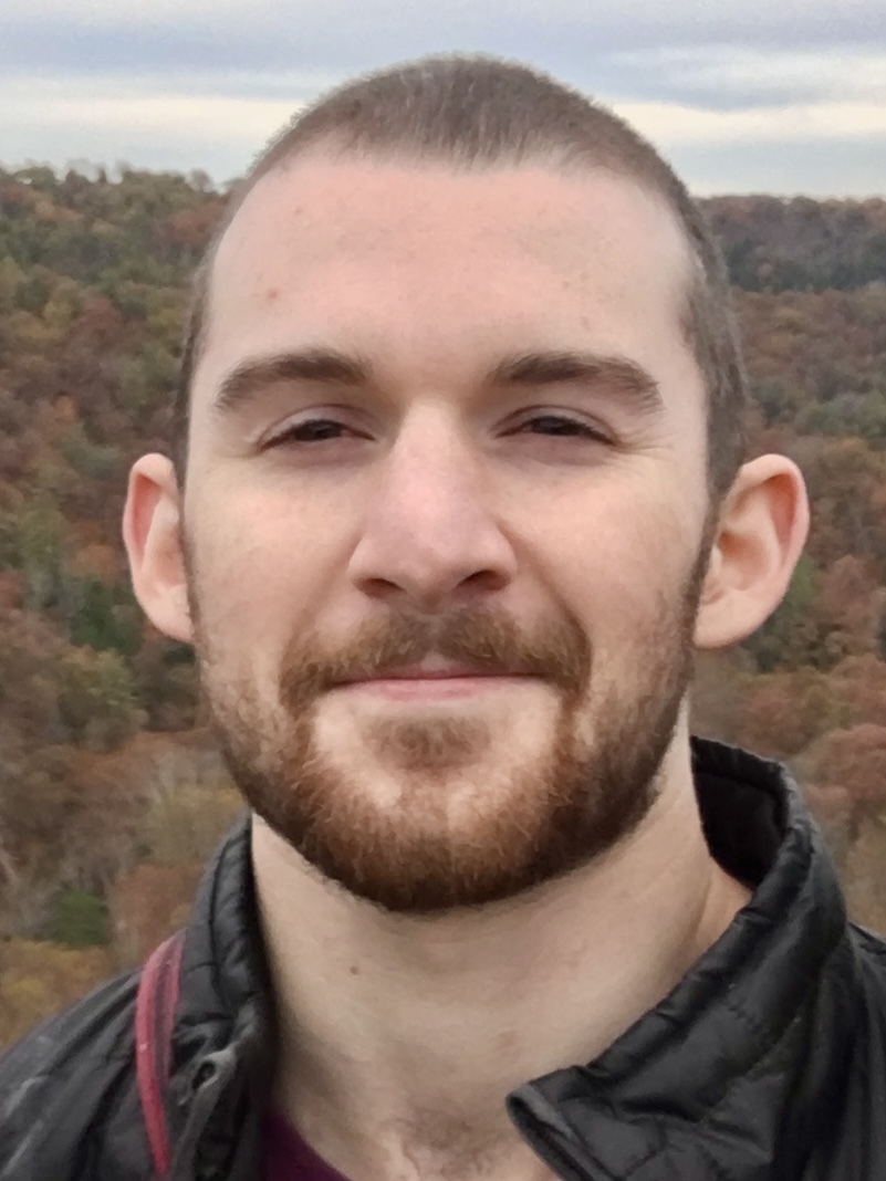 Headshot of Robert Ward standing outside, backgrounded by trees.