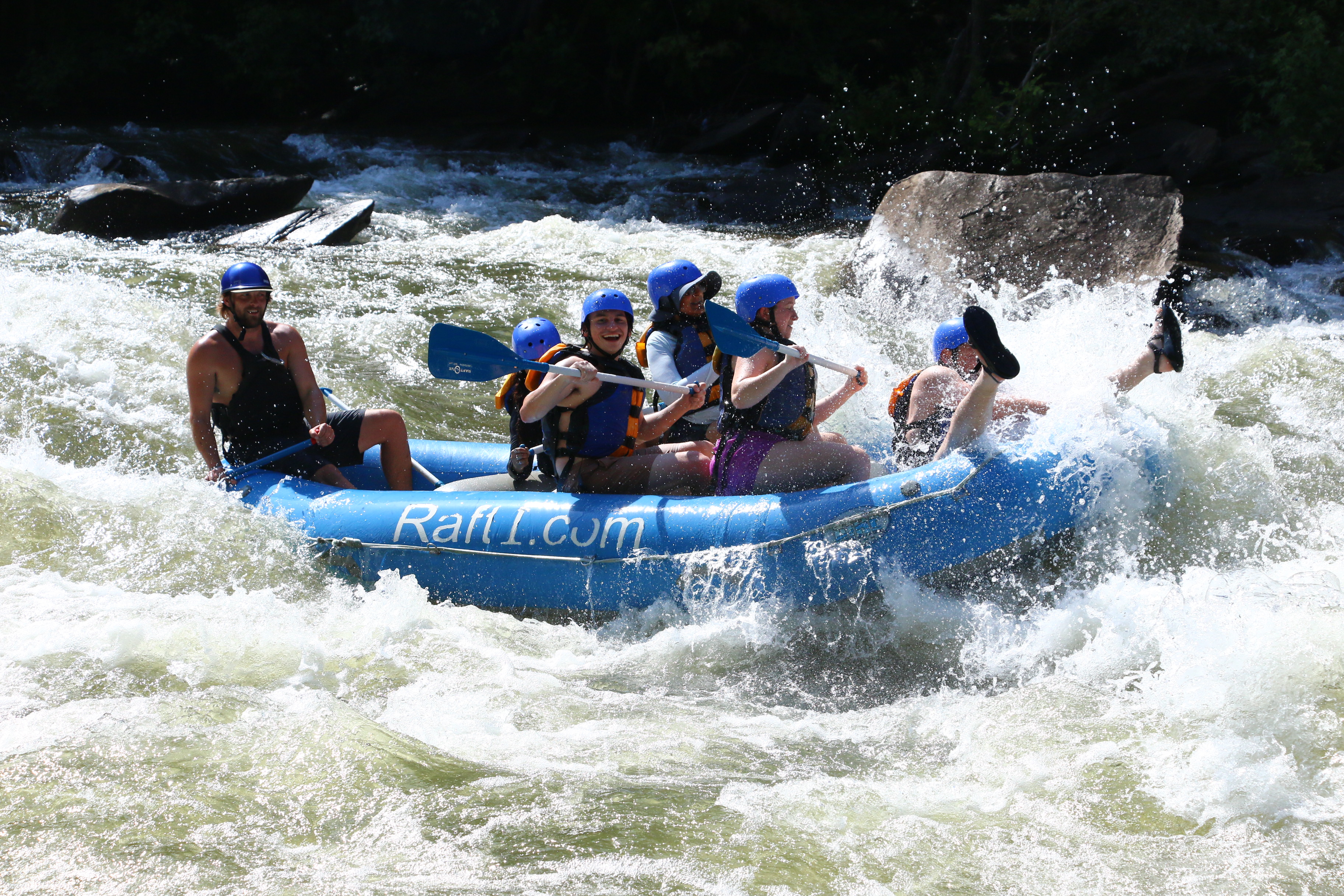 MSEEM Students White Water Rafting in a Blue Boat with Paddles and Helmets